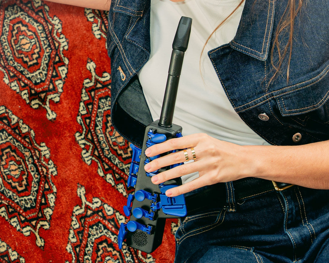A player holding the Travel Sax 2, an electronic saxophone with blue keys
